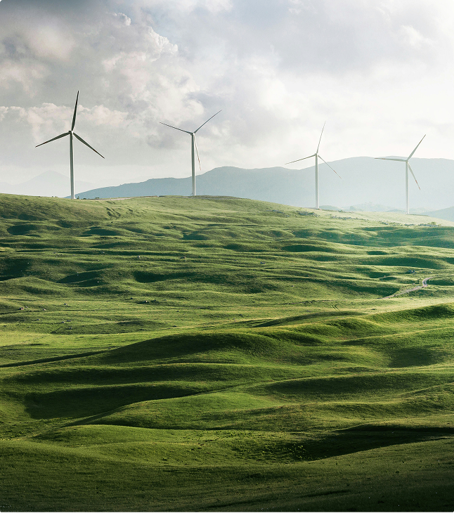 Wind turbines on rolling green hills representing sustainable energy